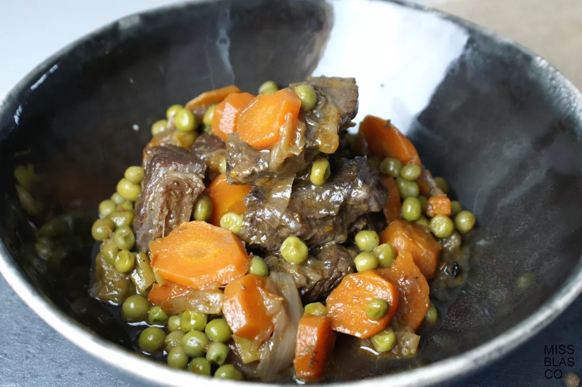beef stew with vegetables in a black bowl