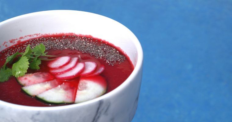 beetroot gazpacho in a bowl with cucumber and radish garnish