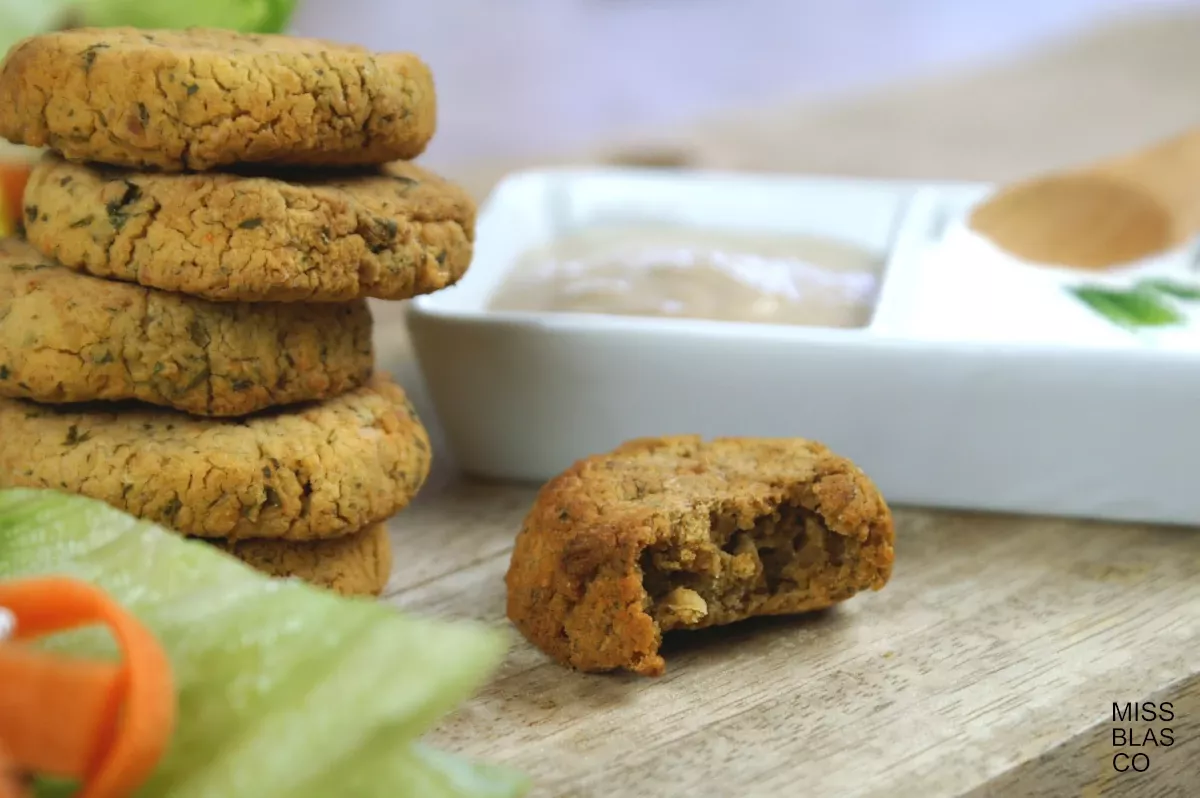 Baked falafel in a serving board with lettuce and yogurt sauce