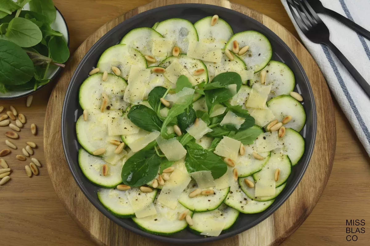 zucchini carpaccio with pinuts in a wooden board