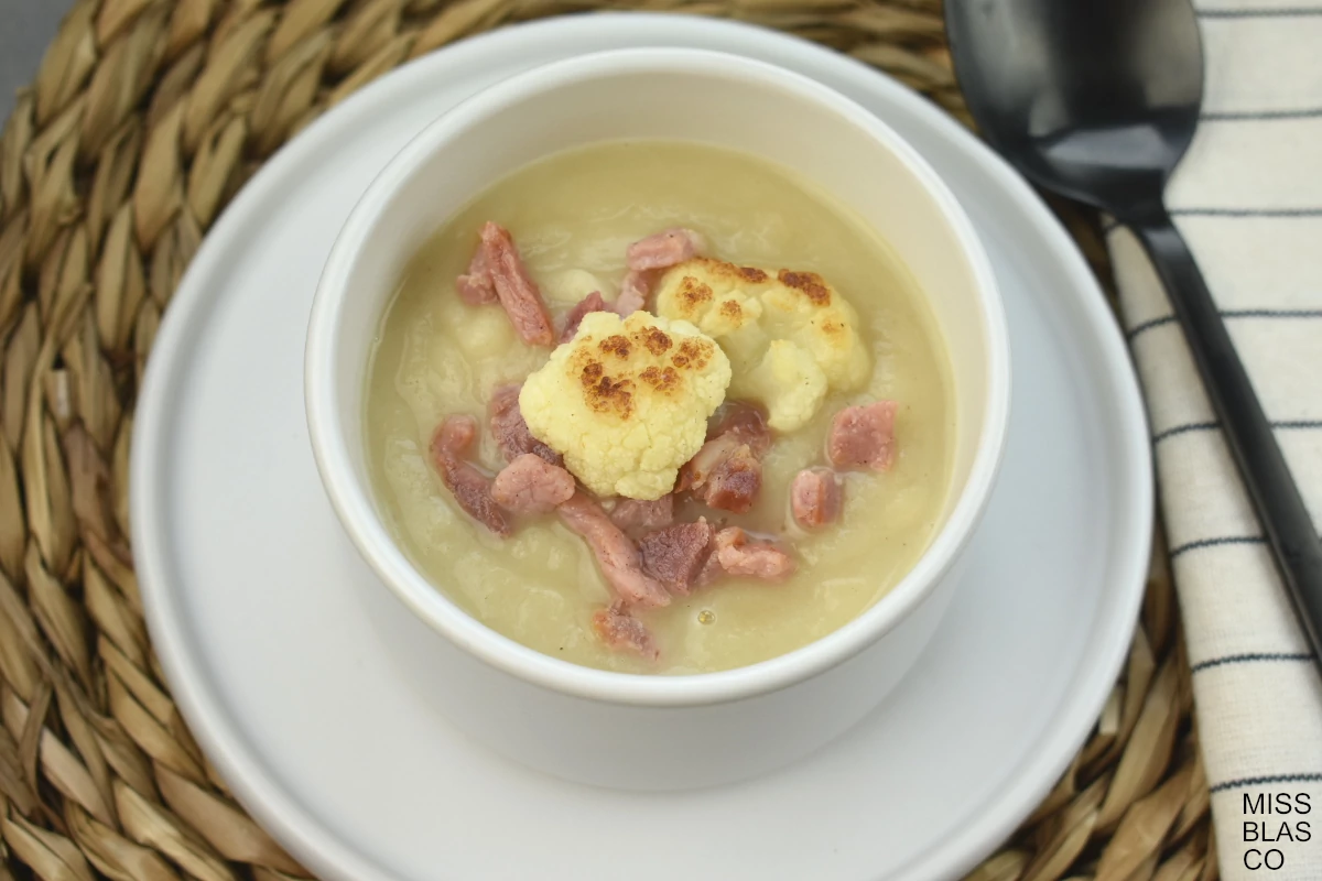 cauliflower soup in a white bowl and a white plate