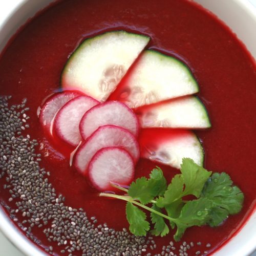 beetroot gazpacho in a bowl with cucumber and radish garnish