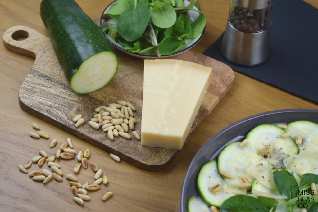 zucchini carpaccio with parmesan cheese and pinuts in a wooden board