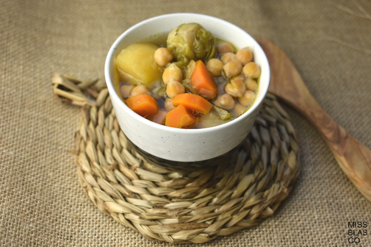 One Pot vegetable soup in a white bowl with a wooden spoon