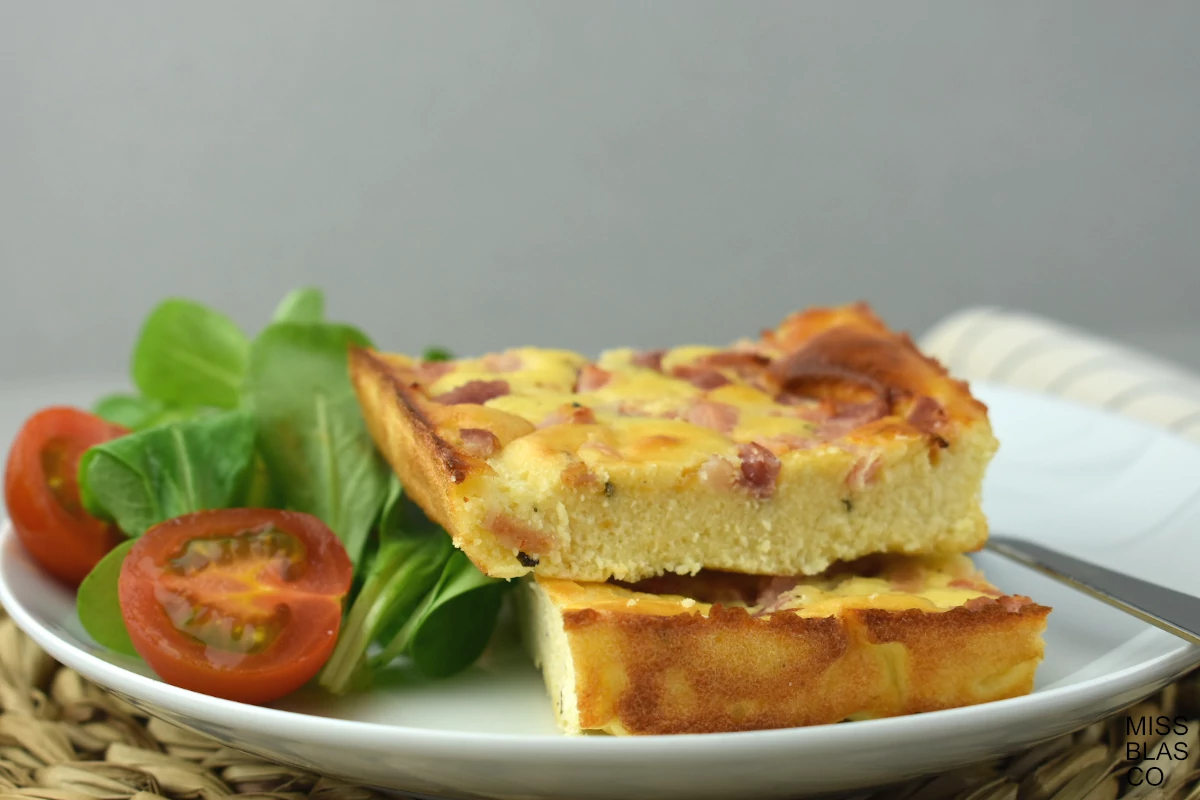 cottage cheese crustless quiche with green leaves and tomatoes