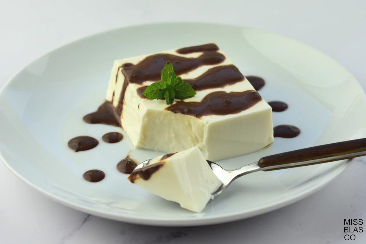 Sugar-free Panna Cotta with chocolate sauce and mint leaves in a white plate
